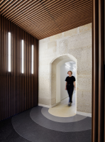 Photographie réalisée par Elodie Dupuis, représentant le sas d’entrée avec ses panneaux acoustiques en bois français, son installation lumineuse et le mur en pierre d’origine